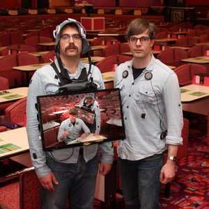 Lloyd and Peter in a bingo hall, recursively shown on the television mounted to Lloyd's chest.